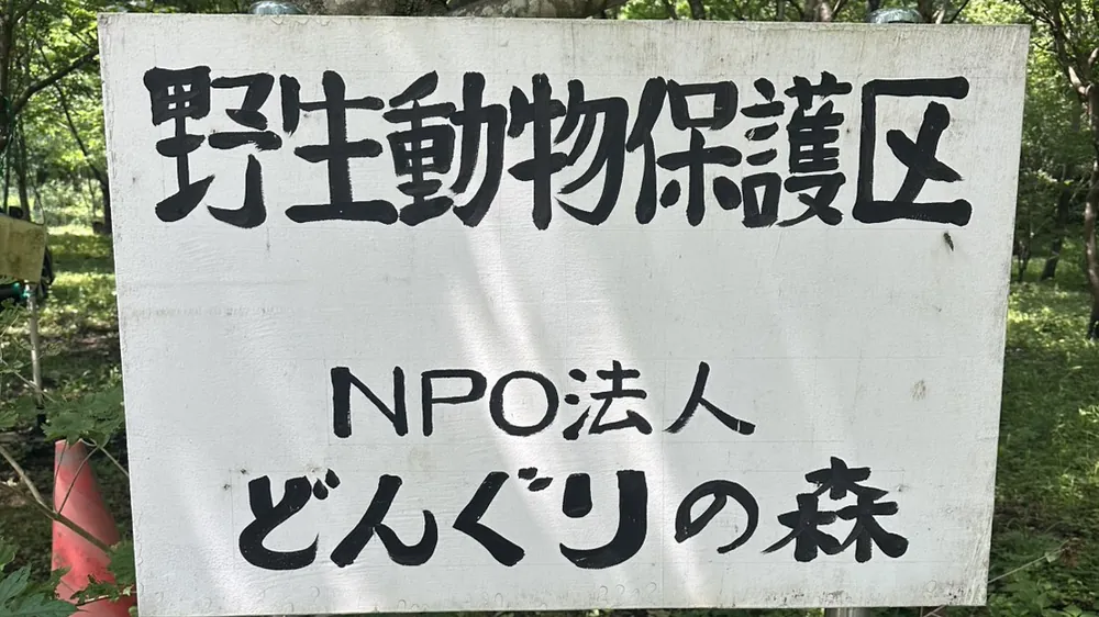 「野生動物保護区 NPO法人どんぐりの森」と書かれた看板